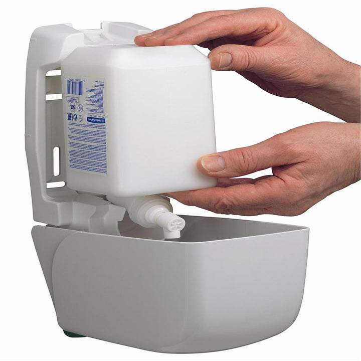 A Person Inserting a Refill Bottle into a White Kimberly Clark 6373 Hand Sanitiser Dispenser