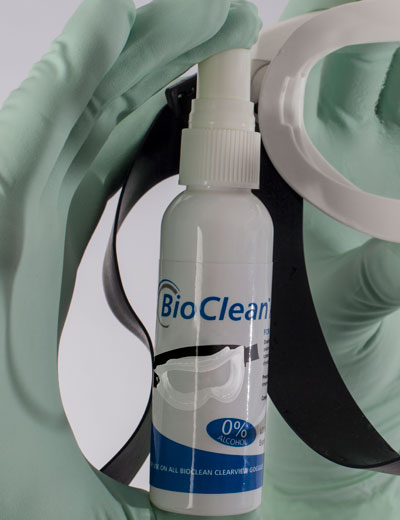 A Person with Green Gloves Holding a Bottle of BioClean™ Anti-fog Goggle Spray