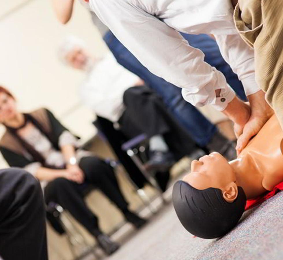 Man performing chest compressions on First Aid dummy - HSE First Aid at Work - Sentinel Laboratories Ltd