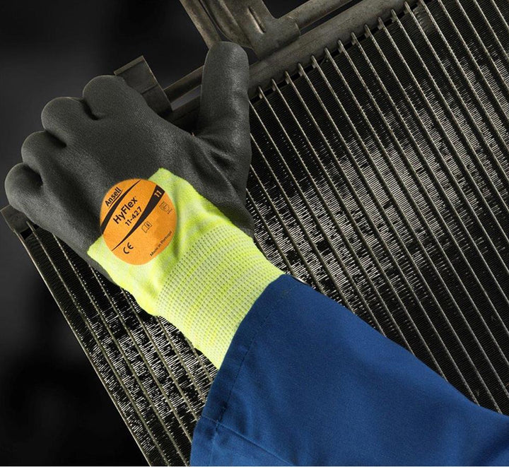 Person Wearing A Blue Jacket and Black, Fluorescent Green HYFLEX® 11-427 (Previously Puretough™ P3000 Tropique) Gloves Holding a Piece of Machinery - Sentinel Laboratories Ltd
