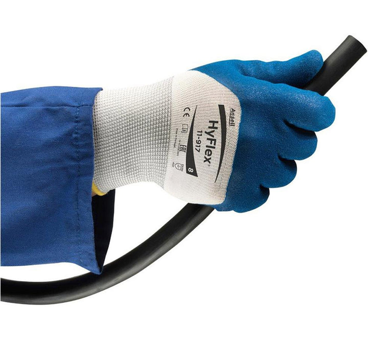 A Person in a Blue Jacket Sleeve Wearing a White and Blue HYFLEX 11-917® (Previously Nitrotough™ N1500) Gloves Holding a Black Pipe - Sentinel Laboratories Ltd