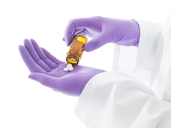 A Person In a White Lab Coat Wearing a Pair of Purple BioClean Omega Pro-tech XP Non Sterile Nitrile Gloves taking Some Pills out of an Amber Container