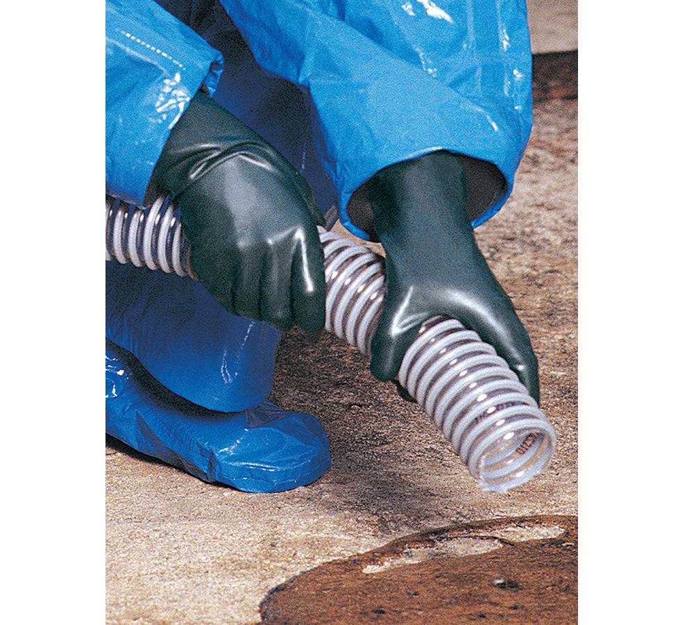A Person Wearing a Blue Coverall Wearing a Pair of Black Showa Best 892 Best® Viton® II Unlined Viton over Butyl, 0,30mm Thick Gloves Holding a Ribbed Tube - Sentinel Laboratories Ltd