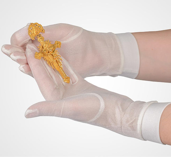 A Person Wearing a Pair of White SENSI-TOUCH® Silk Glove Liners, Cuffed Holding a Golden Object - Sentinel Laboratories Ltd