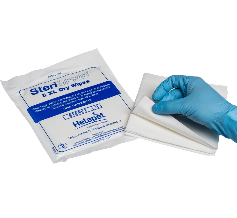 A Person Wearing a Blue Glove Holding a Stack of White SteriClean® XL Dry Wipes (30 x 30cm) - Sentinel Laboratories Ltd