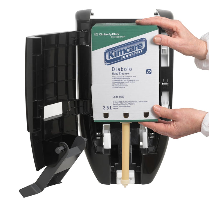 A White, Blue and Green Box of 9533 Kimcare Industrie Diabolo Hand Cleanser In an Open Black Dispenser