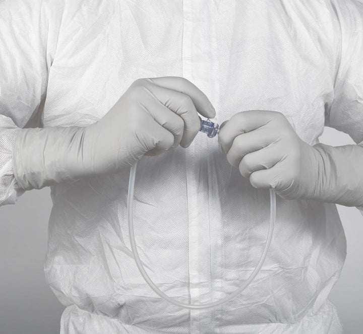 A Person Wearing a Pair of White Long Cuff Length 11821 KIMTECH PURE* G3 Sterile STERLING* Nitrile Gloves Over a White Lab Coat, Holding a Clear Tube - 30cm Hand Specific - Sentinel Laboratories Ltd