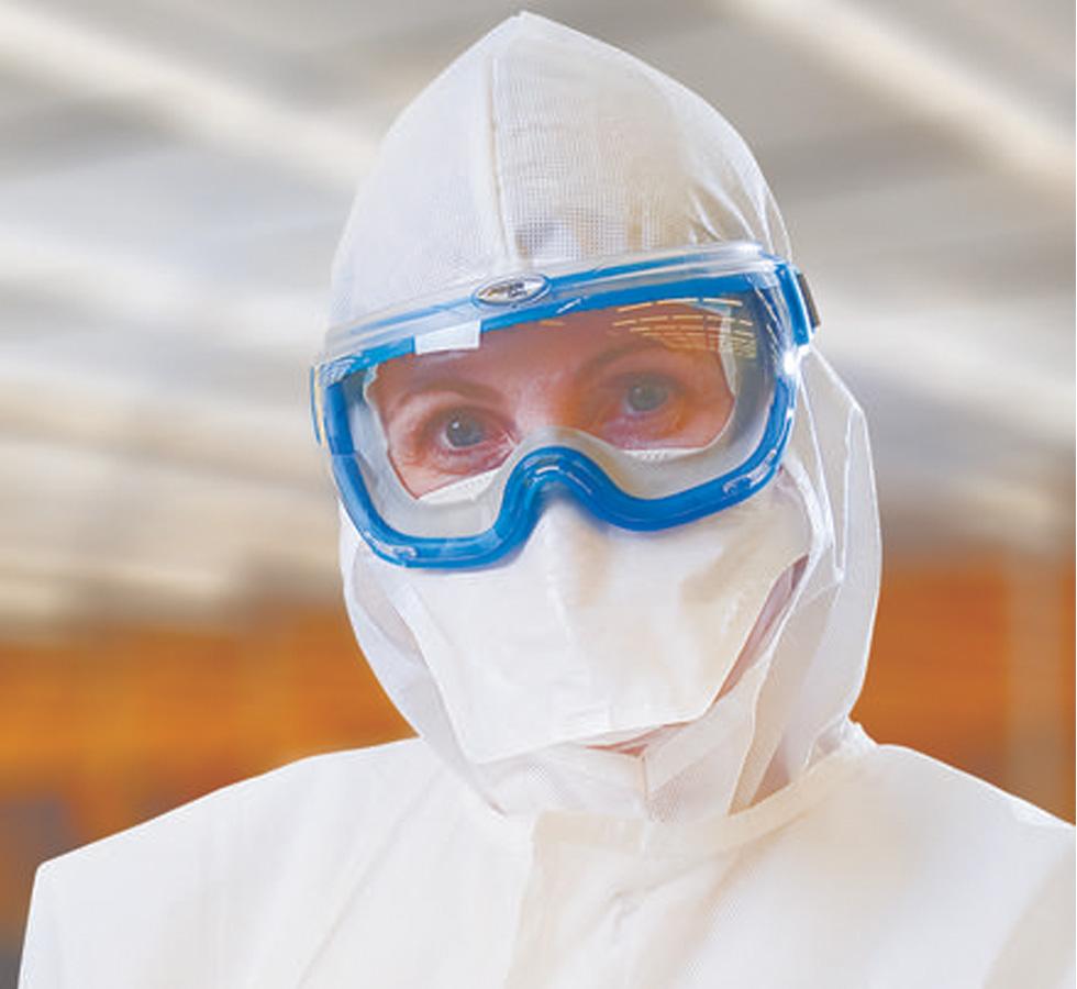 A Woman Wearing a White 62483 KIMTECH PURE* M3 Sterile Pouch Face Mask with White Lab Coveralls and Blue Protective Goggles - Sentinel Laboratories Ltd
