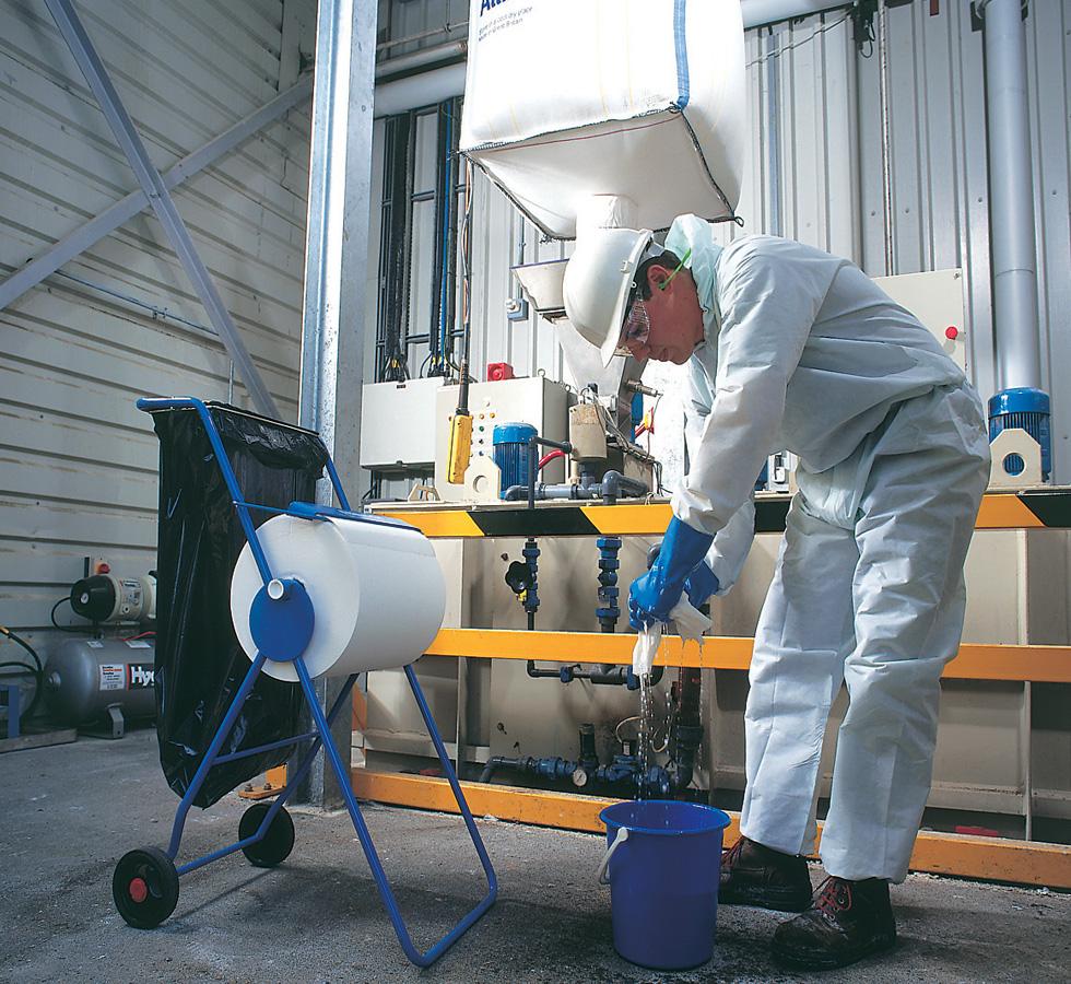 A Man In White Coveralls Wringing a 7452 WYPALL* L40 Wipers, Large Roll on a Blue Dispenser Stand - White - Sentinel Laboratories Ltd