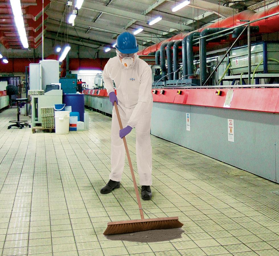 A Man In a White KLEENGUARD* A20+ Breathable Particle Protection Hooded Coverall with Blue Hard Hat, White Mask and Purple Gloves Sweeping a Pile of Dirt and Dust - Sentinel Laboratories Ltd