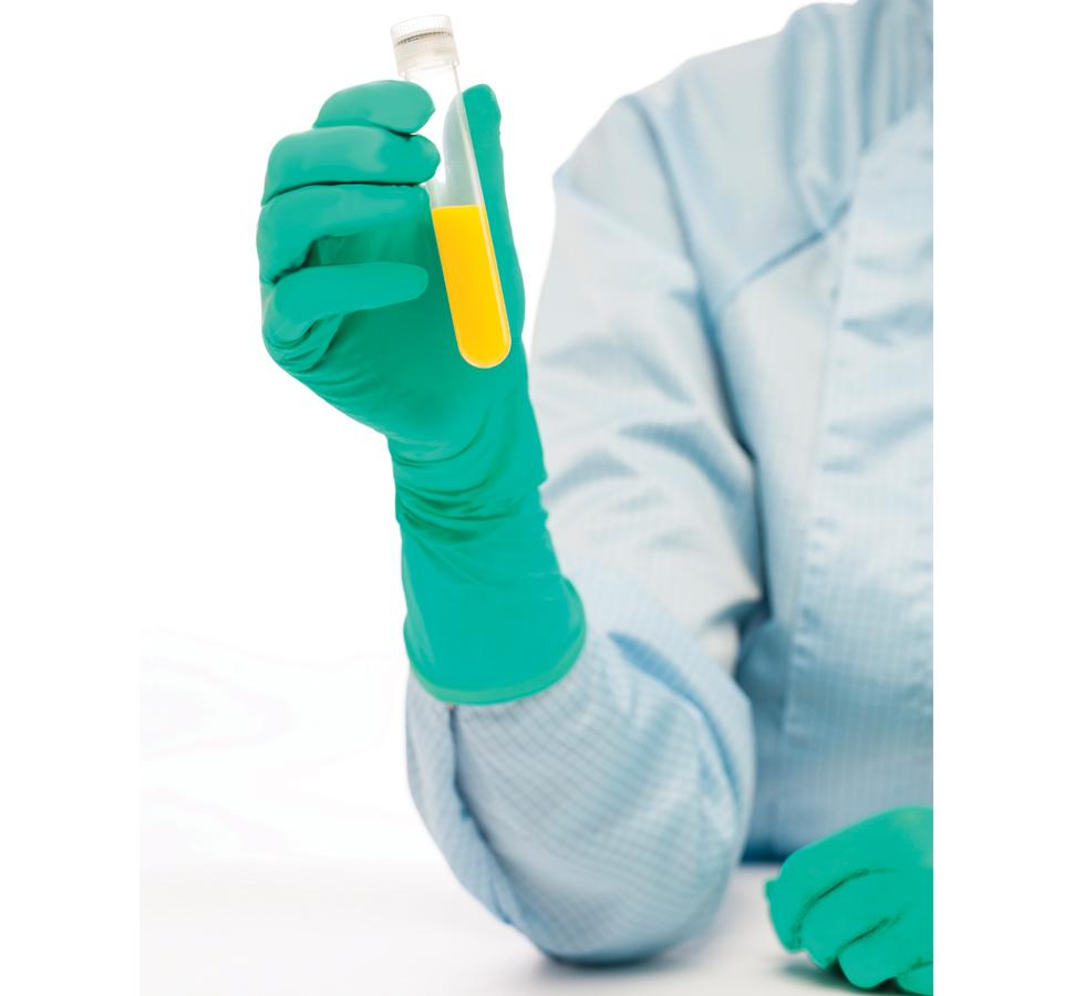 A Person In a Blue Lab Coat Wearing A Pair of Green Long Length Cuff BioClean Jade™ Sterile 300mm Length Nitrile Gloves Holding a Vial of Yellow Liquid - Sentinel Laboratories Ltd