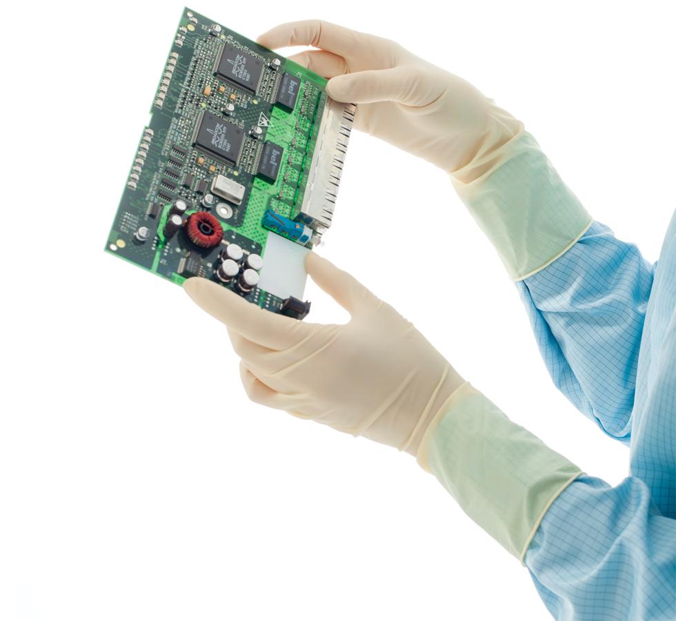 A Person in a Blue Lab Coat Wearing White BioClean Legacy™ Non-Sterile 300mm Length Latex Gloves Holding a Large Printed Circuit Board - Sentinel Laboratories Ltd