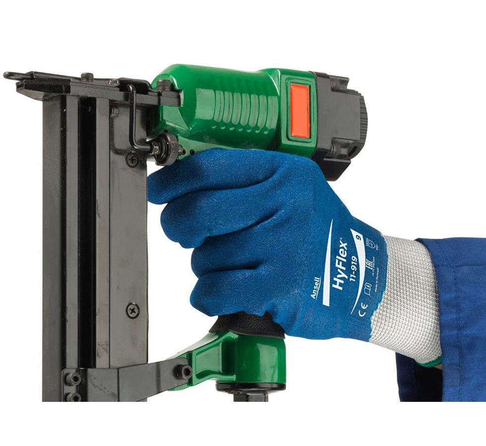 A Person Wearing Blue and Grey HYFLEX® 11-919 (Previously Nitrotough™ N1700) Gloves Holding a Green and Black Staple Gun  - Sentinel Laboratories Ltd