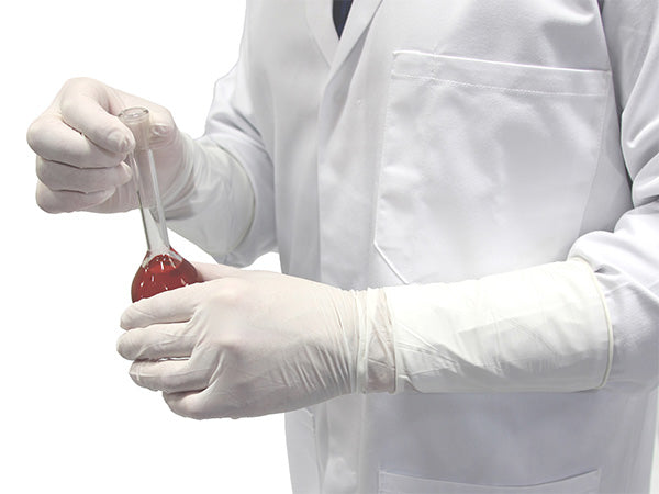 A Person in a White Lab Coat and a Pair of BioClean Omega Nerva Nitrile White ONAW Non Sterile Gloves Holding a Vial of Red Liquid