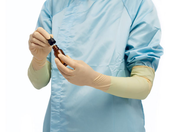 A Person in a Blue Lab Coat Wearing a Pair of BioClean Profile PLAL Latex Ambidextrous Non Sterile Gloves Holding a Vial and Pipette