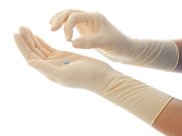 A Person Wearing Nitritex Profile SENSA XP Latex Ambidextrous Gloves Holding Two Blue Pills