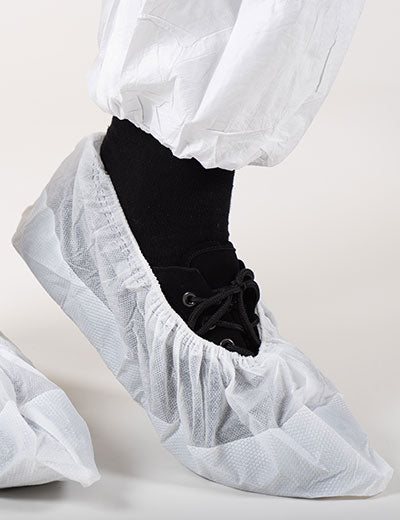 A Person Wearing a Pair of White BioClean Dual Overshoes S-BDOS Over a Black Shoe