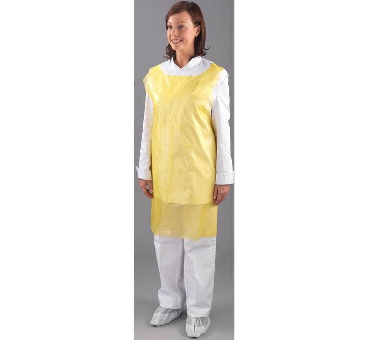 A Woman Wearing a Yellow Shield 69 x 107cm Polythene Apron Over a White Coverall and Overshoes - Sentinel Laboratories Ltd