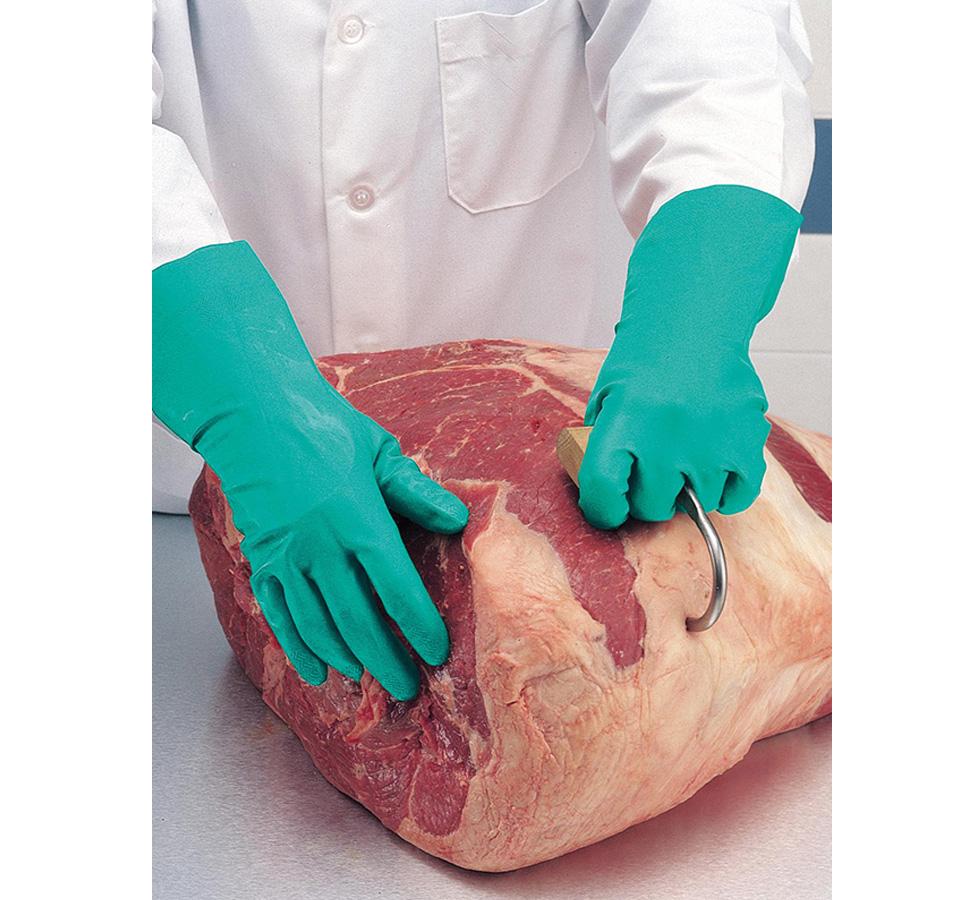 A Butcher in a White Coat Wearing a Pair of Long Cuff Length Green Showa Best 747 Nitri-Solve® Nitrile Gloves with a Meat Hook in a Slab of Beef - Flock Lined 0,56mm thick, 480mm long - Sentinel Laboratories Ltd