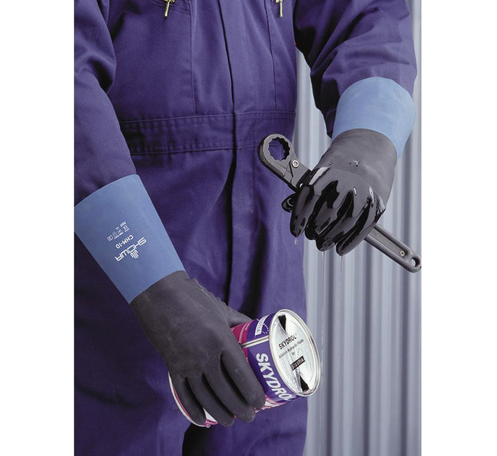 A Person In Purple Coveralls Wearing a Pair of Black Showa Best CHM Chem Master® 0,66mm Thick Gloves with Off-Blue Coloured Gloves Holding a Socket Wrench and container of Paint - Sentinel Laboratories Ltd